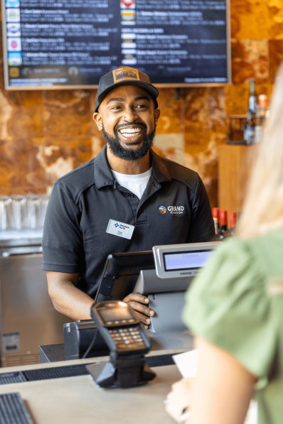 Grand Canyon cashier team member smiling at guest Grand Canyon cashier team member smiling at guest