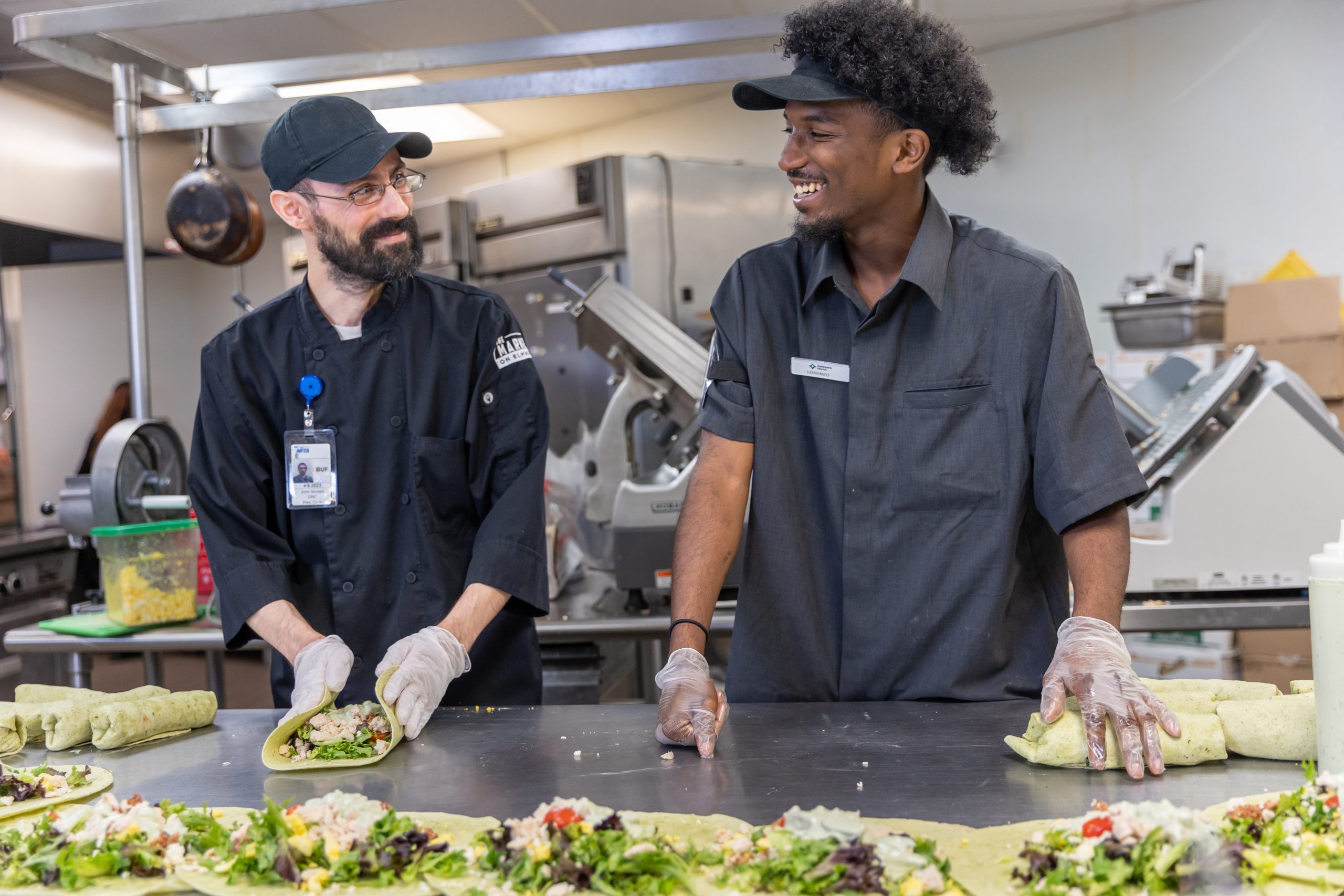 Jobs_BuffaloAirport_cooks_2_2022 Two prep cooks smiling at each other