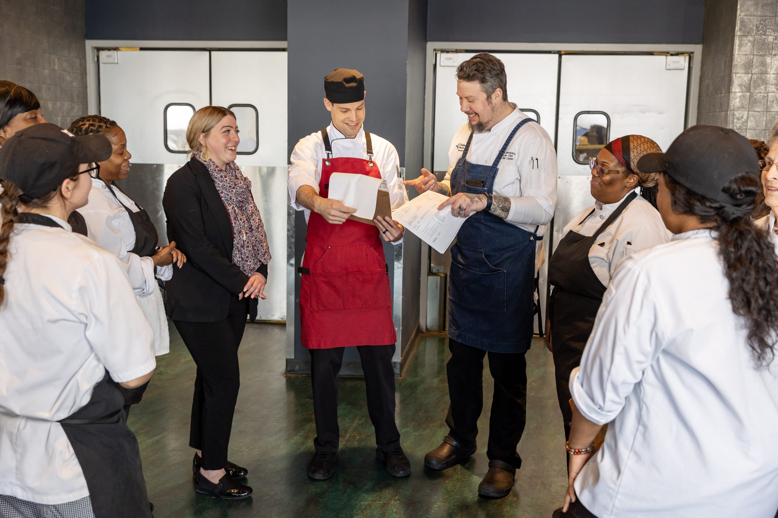 Group of chefs smiling during pre-service meeting