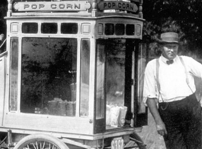 1915_Jacobs brother leaning on popcorn stand 1915_Jacobs brother leaning on popcorn stand