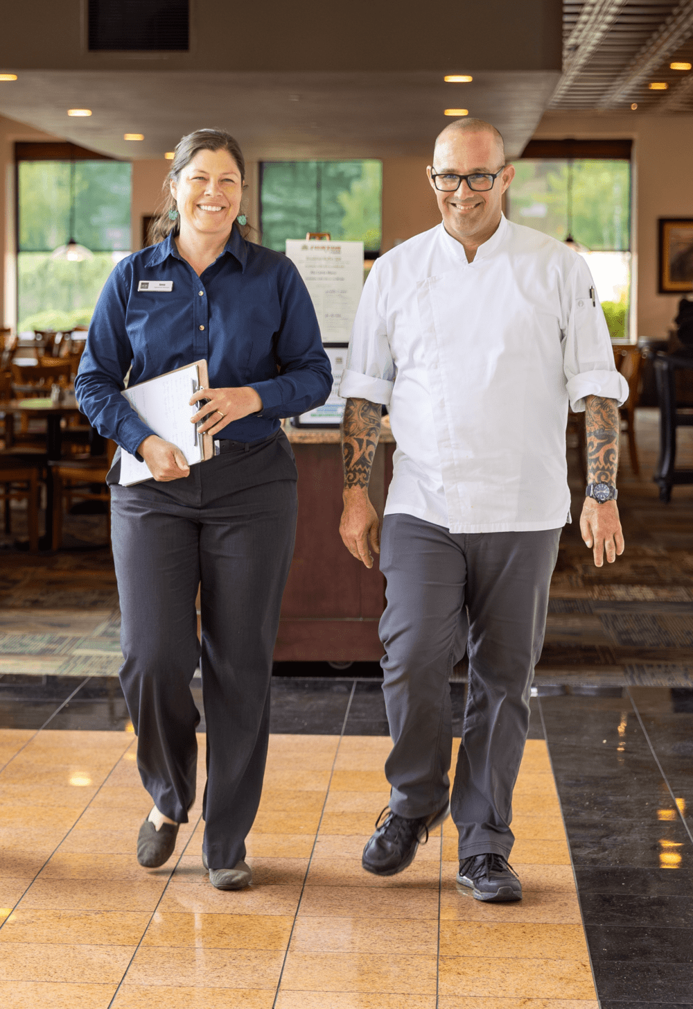 Front of house manager and chef smiling and walking away from restaurant
