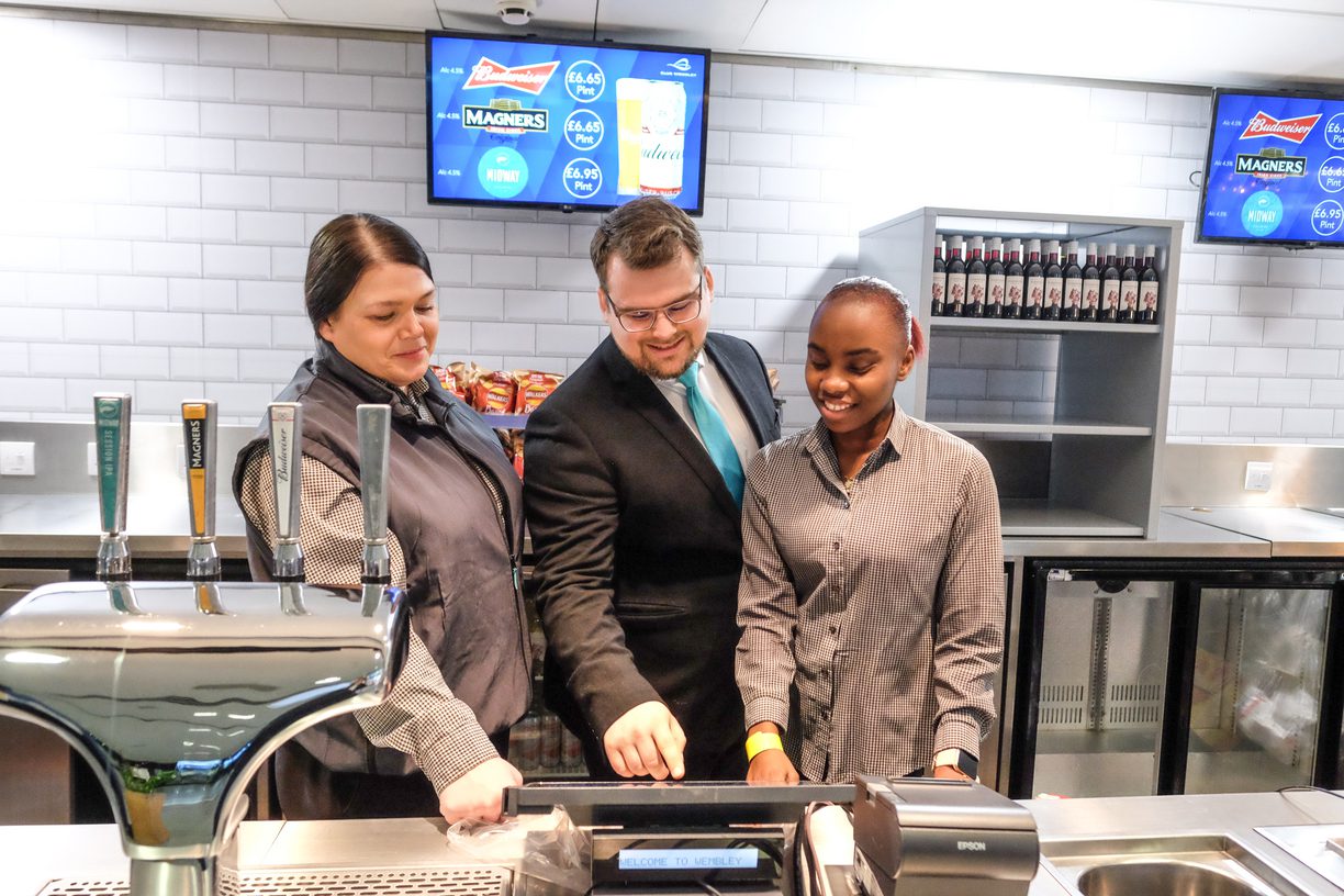 Concessions team smiling while looking at POS till