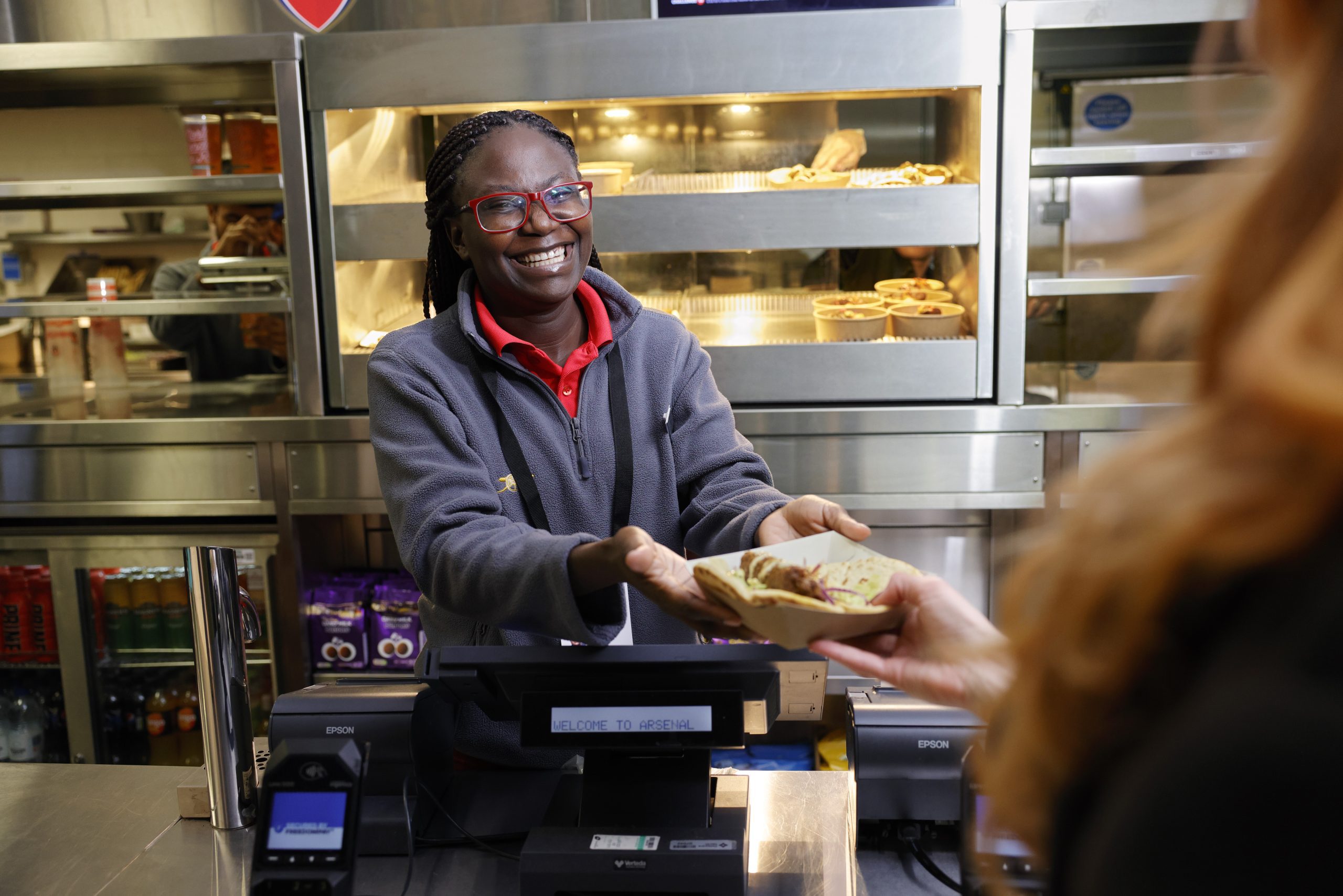 Delaware North team member smiling at guest and handing over hot food