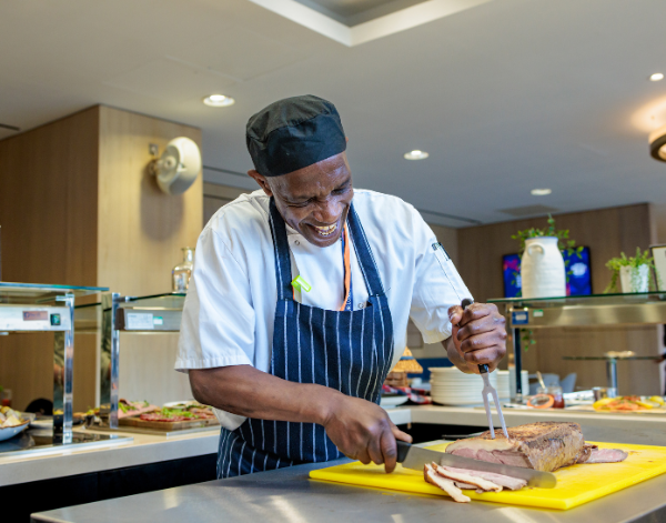 London Stadium Chef smiling while carving meat