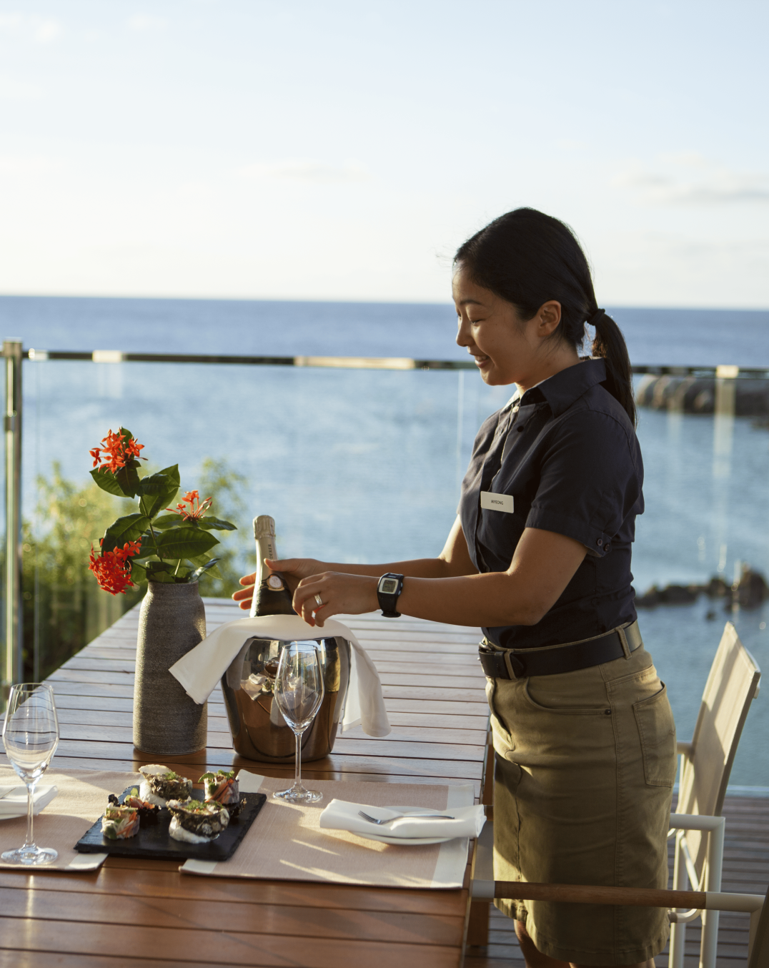 Server delivering alcoholic beverage to a table outside
